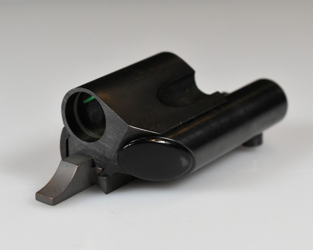 Close-up view of the TC Insta-Sight collimator sight, showcasing the cylindrical body and green reticle window.