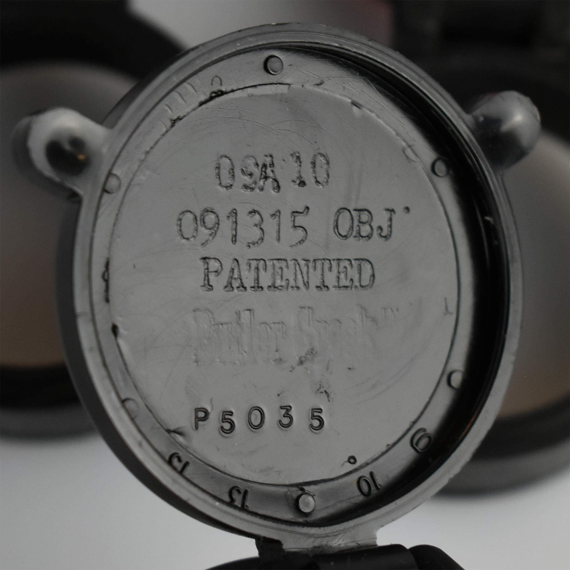 Close-up of the marked interior of a lens cover, showing patent information and branding from Butler Creek.