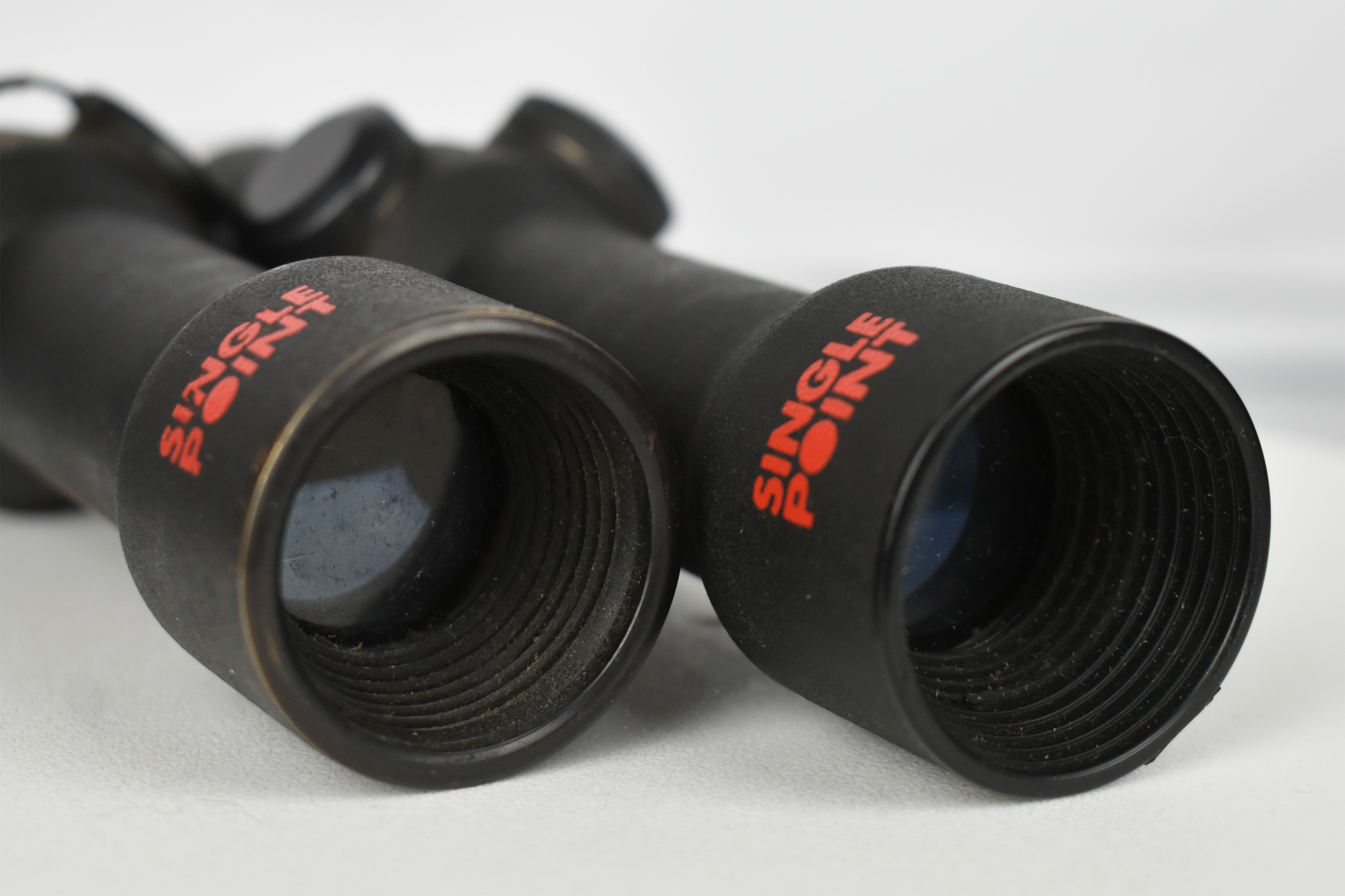 Close-up view of two Singlepoint optics with visible lenses and branding, highlighting the design and condition.