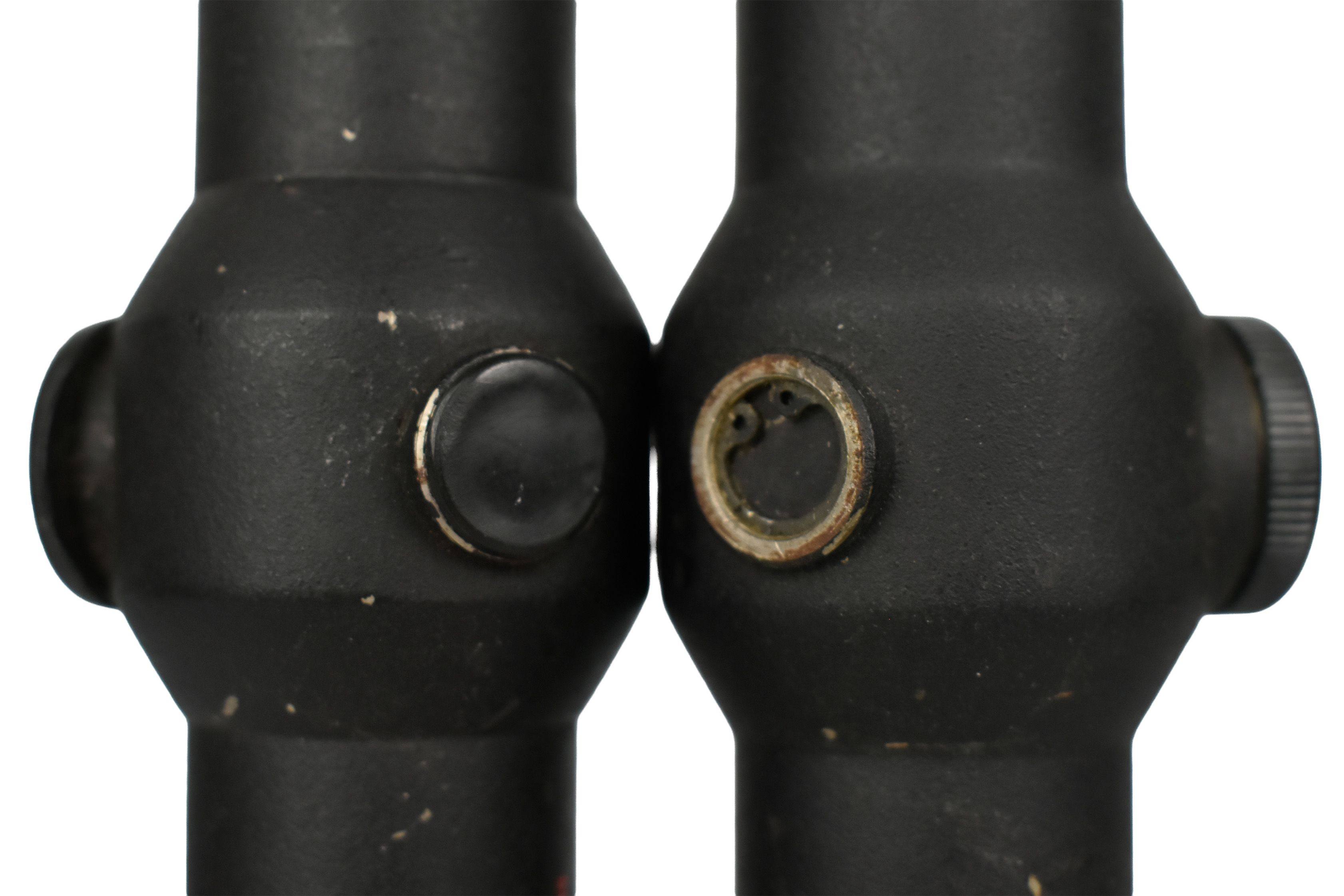 Close-up view of the rear of two optical sights, showcasing their cylindrical design and adjustment features.