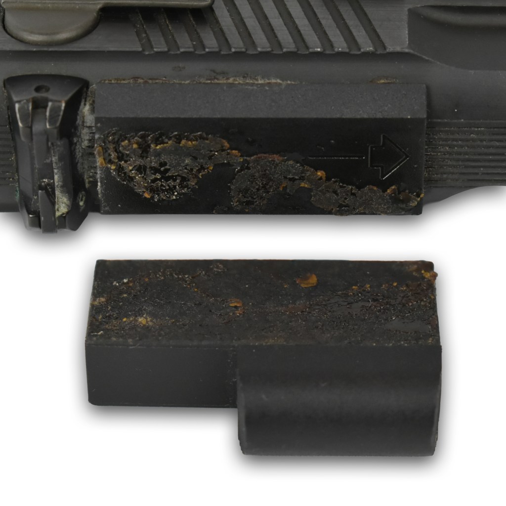 Close-up of a firearm sight showing rust and degradation on the mounting base.