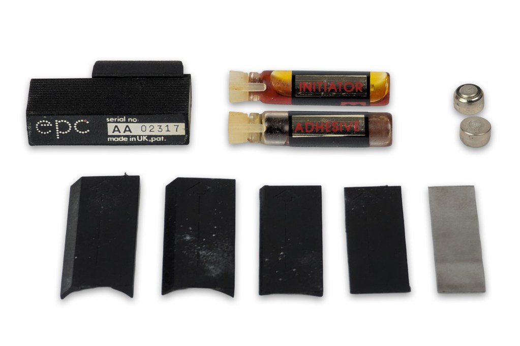 EPC subminiature red dot sight components including adhesive initiator and mounting plates.