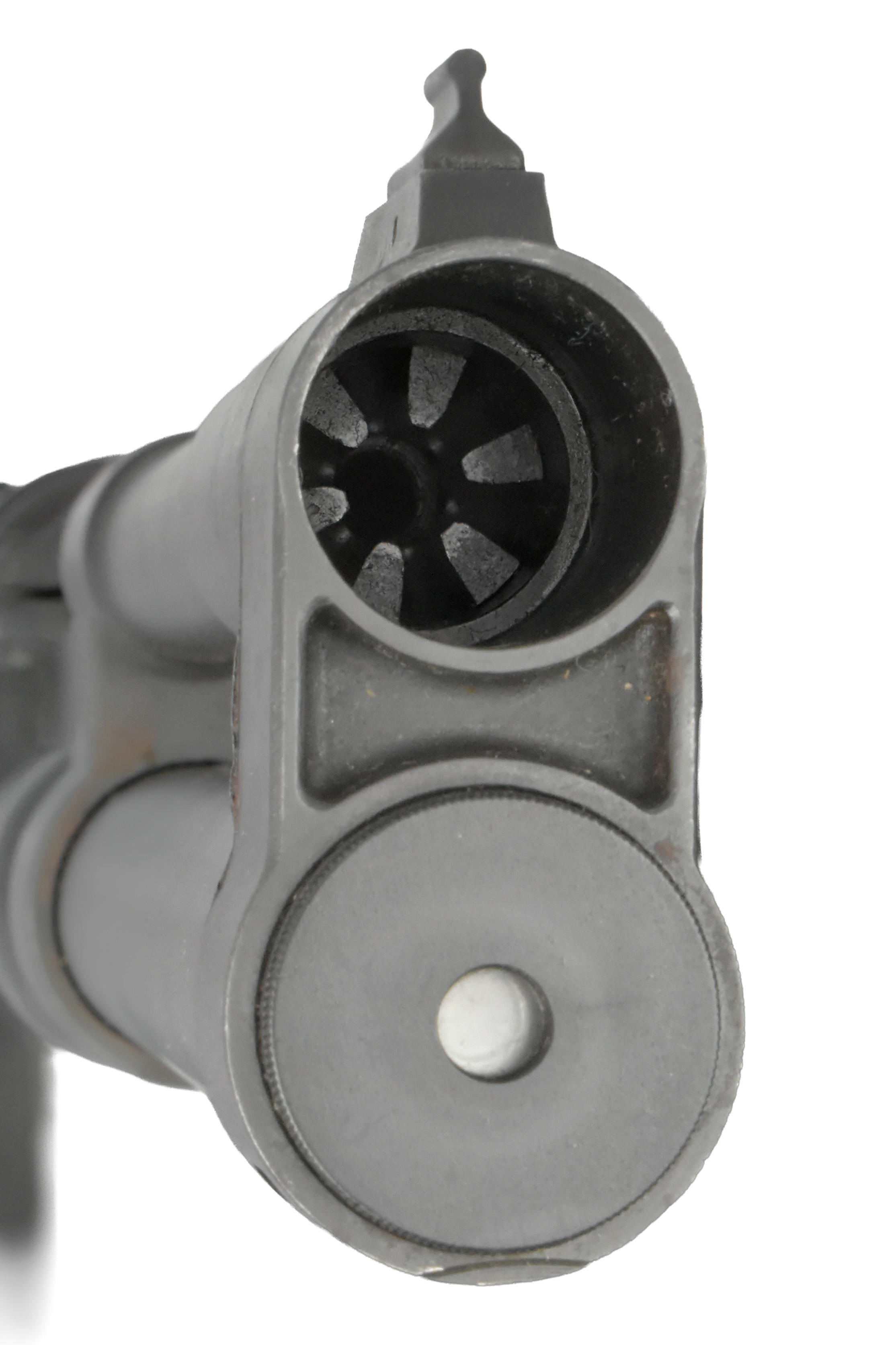 Close-up view of the muzzle of a firearm showing the barrel and front sight.