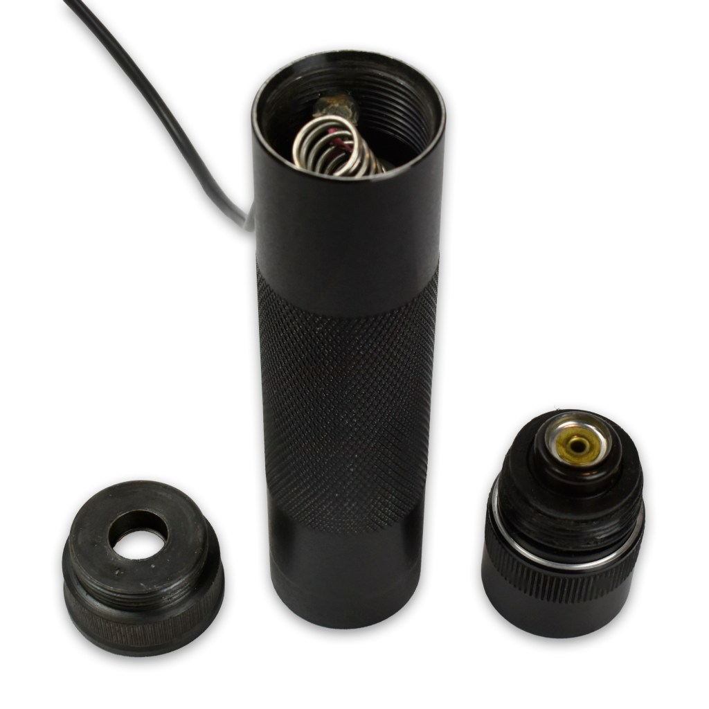 Image of a flashlight device with a halogen-beam bulb and remote pressure switch, alongside two end caps. The flashlight features a textured grip and is designed for use with specific shotgun models.