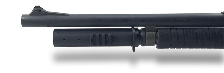 Close-up view of a shotgun's magazine tube extension with a tactical light attachment, showcasing a sleek black design and a mounting rail.