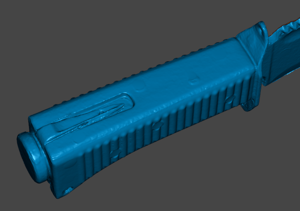 Close-up view of a blue knife handle with detailed texture and features.